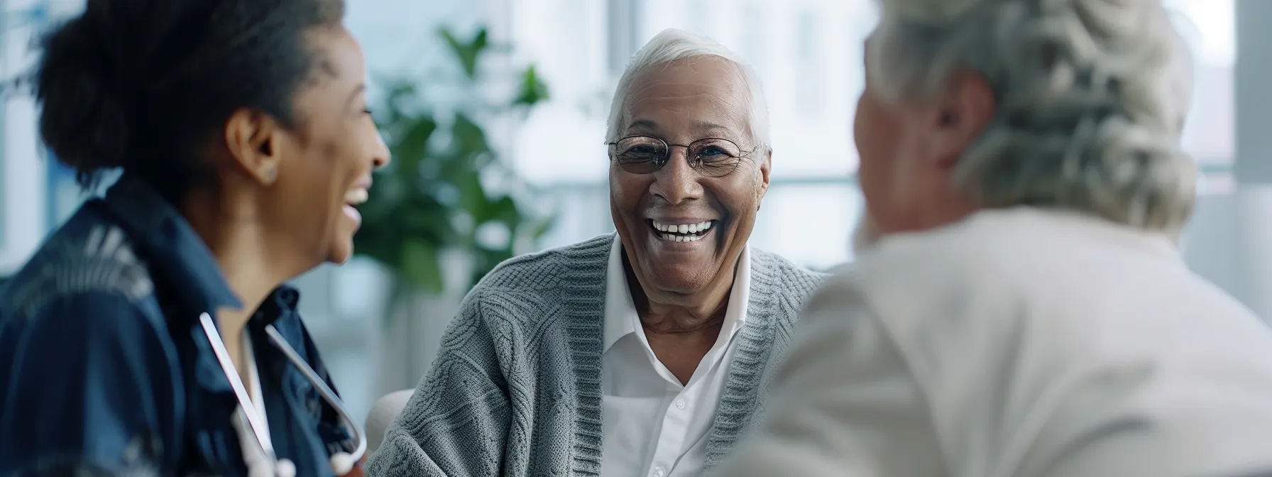 an elderly couple smiling and talking to a geriatrician in an office setting, with the geriatrician listening attentively.